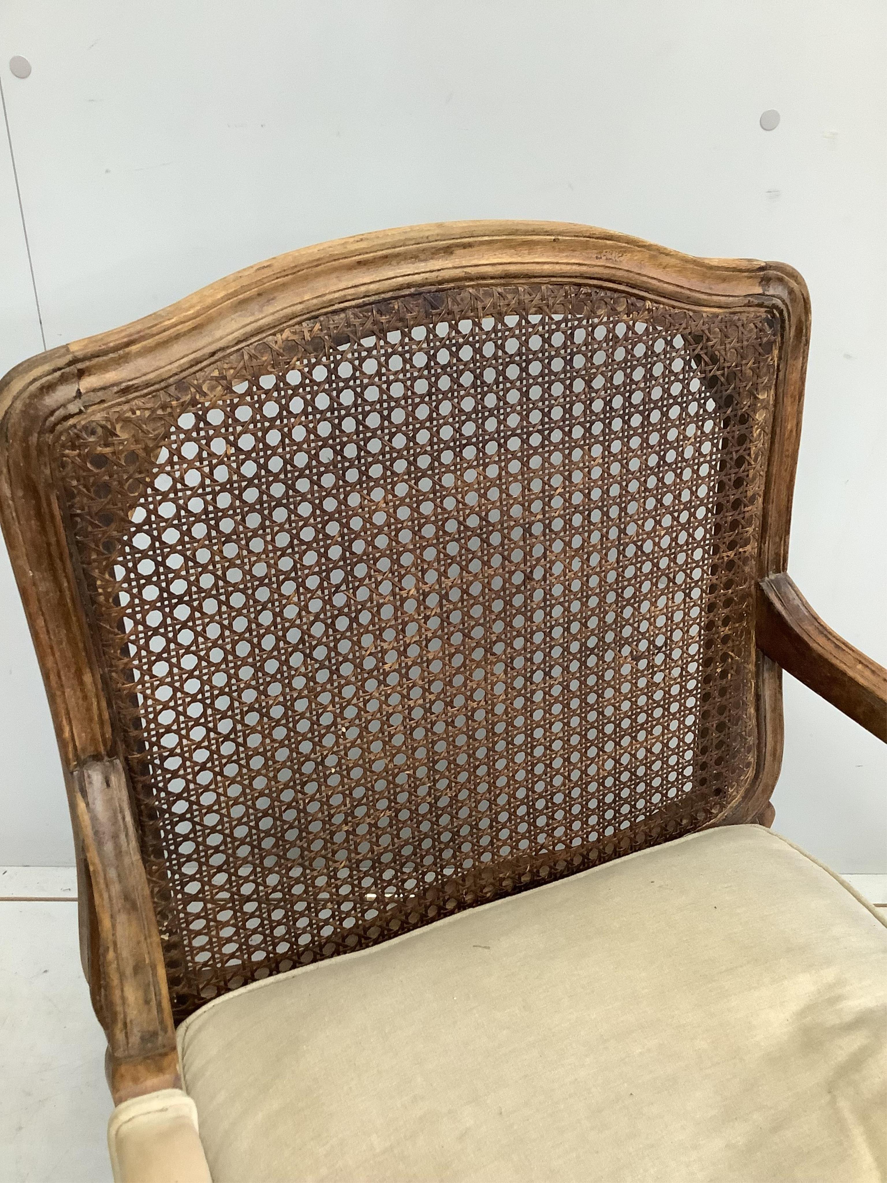 A Louis XVI style caned back beech armchair, width 64cm, depth 64cm, height 87cm